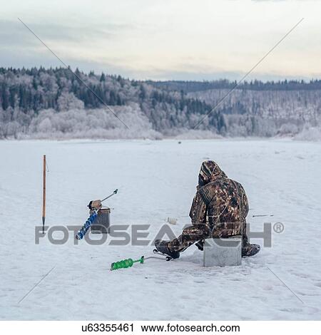 Stock Image - Man ice-fishing, Ural, Sverdlovsk, Russia. Fotosearch