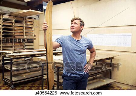 Stock Photography - Man in workshop, inspecting skis. Fotosearch