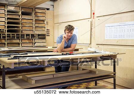 Stock Image - Man in workshop, making ski equipment, problem solving. Fotosearch