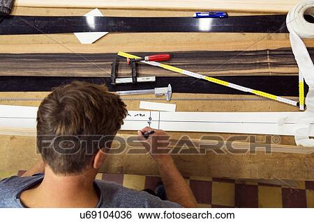 Stock Photograph - Man in workshop, making ski equipment, overhead view. Fotosearch