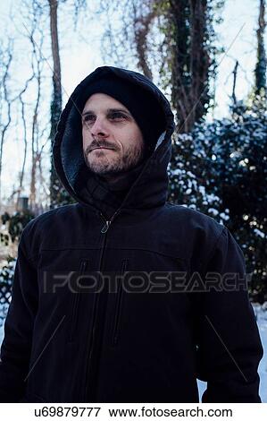 Man keeping warm in hooded jacket in winter weather View Large Photo Image Stock Photo - Man keeping warm in hooded jacket in winter weather. Fotosearch