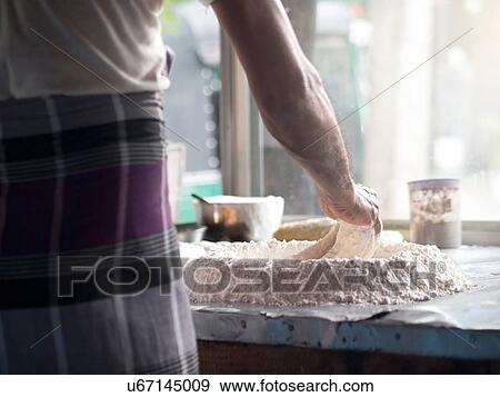 Stock Photo - Man preparing roti dough. Fotosearch