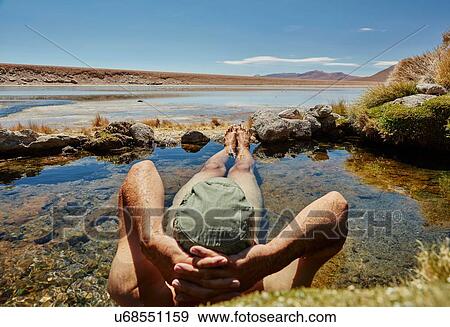 Stock Photo - Man relaxing in water pool, rear view, Salar de Chiguana, Chiguana, Potosi, Bolivia, South America. Fotosearch