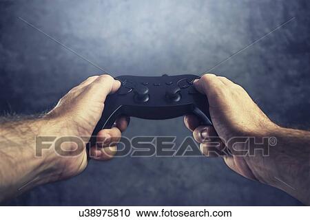 Stock Image - Man using controller to play video games.. Fotosearch