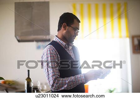 Man using digital tablet at home View Large Photo Image Picture - Man using digital tablet at home. Fotosearch