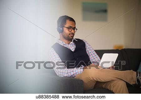 Man using digital tablet at home View Large Photo Image Stock Photo - Man using digital tablet at home. Fotosearch