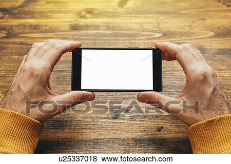 Stock Photo - Man using smart phone in horizontal landscape orientation.. Fotosearch