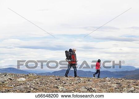 Stock Image - Man with sons hiking in mountain landscape, Jotunheimen National Park, Lom, Oppland, Norway. Fotosearch
