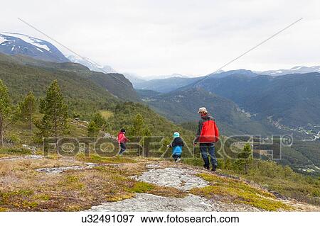 Man with sons hiking in mountain landscape, rear view, Jotunheimen National Park, Lom, Oppland, Norway View Large Photo Image Stock Photo - Man with sons hiking in mountain landscape, rear view, Jotunheimen National Park, Lom, Oppland, Norway. Fotosearch