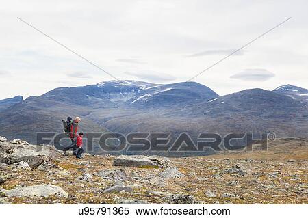 Stock Photography - Man with sons hiking in mountain landscape, Jotunheimen National Park, Lom, Oppland, Norway. Fotosearch