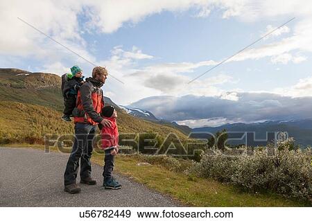 Man with sons looking out at mountain landscape, Jotunheimen National Park, Lom, Oppland, Norway View Large Photo Image Stock Photo - Man with sons looking out at mountain landscape, Jotunheimen National Park, Lom, Oppland, Norway. Fotosearch