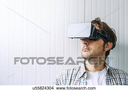 Picture - Man with VR headset goggles.. Fotosearch