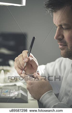 Stock Photo - Man working on false tooth.. Fotosearch