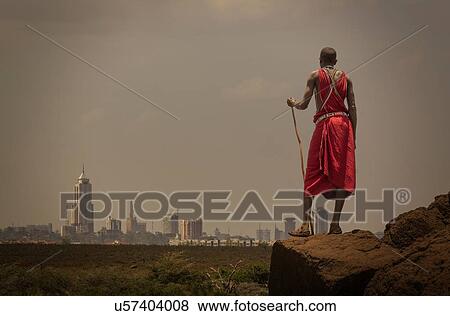 Stock Photo - Masai man with traditional dress watching Nairobi's skyline, Nairobi, Nairobi Area, Kenya. Fotosearch