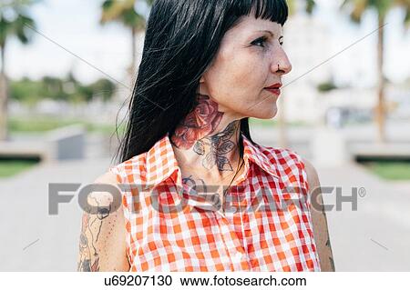 Stock Image - Mature female hipster with tattooed neck, close up. Fotosearch