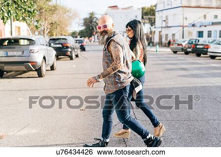 Stock Photograph - Mature hipster couple crossing road, Valencia, Spain. Fotosearch