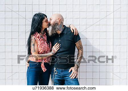 Mature hipster couple kissing in front of white wall View Large Photo Image Stock Photo - Mature hipster couple kissing in front of white wall. Fotosearch
