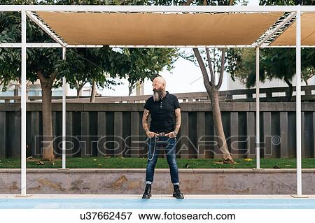 Mature male hipster standing below canopy with hands in pockets View Large Photo Image Stock Photo - Mature male hipster standing below canopy with hands in pockets. Fotosearch