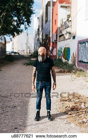 Mature male hipster standing in alleyway View Large Photo Image Stock Image - Mature male hipster standing in alleyway. Fotosearch
