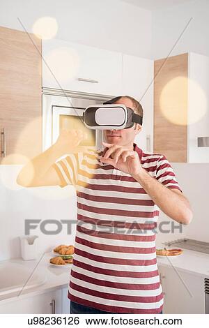 Mature man looking through virtual reality headset in kitchen View Large Photo Image Stock Photograph - Mature man looking through virtual reality headset in kitchen. Fotosearch