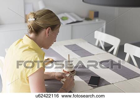 Stock Photograph - Mature woman making macrame at table. Fotosearch