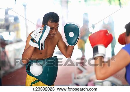 Mature woman practicing boxing with male trainer in gym View Large Photo Image Stock Image - Mature woman practicing boxing with male trainer in gym. Fotosearch