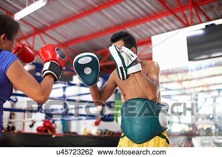Mature woman practicing boxing with male trainer in gym View Large Photo Image Stock Image - Mature woman practicing boxing with male trainer in gym. Fotosearch