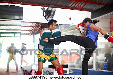 Mature woman practicing kickboxing with male trainer in gym View Large Photo Image Stock Photography - Mature woman practicing kickboxing with male trainer in gym. Fotosearch