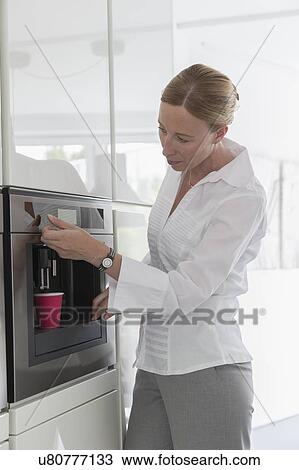 Mature woman preparing coffee in modern kitchen View Large Photo Image Stock Image - Mature woman preparing coffee in modern kitchen. Fotosearch