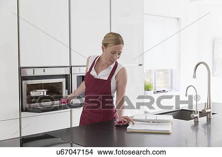 Mature woman preparing food in modern kitchen View Large Photo Image Picture - Mature woman preparing food in modern kitchen. Fotosearch
