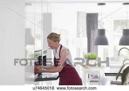 Mature woman preparing food in modern kitchen View Large Photo Image Stock Photo - Mature woman preparing food in modern kitchen. Fotosearch