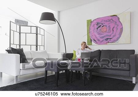 Mature woman sitting in modern living room View Large Photo Image Stock Photography - Mature woman sitting in modern living room. Fotosearch