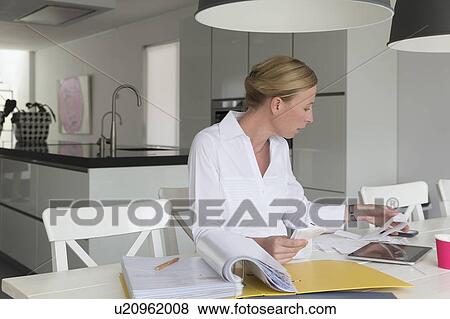 Stock Photo - Mature woman working at table. Fotosearch
