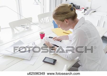 Mature woman working at table View Large Photo Image Stock Photo - Mature woman working at table. Fotosearch