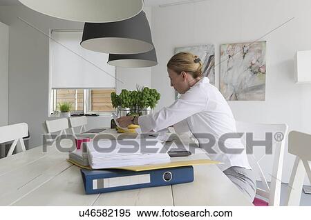 Stock Photography - Mature woman working at table. Fotosearch