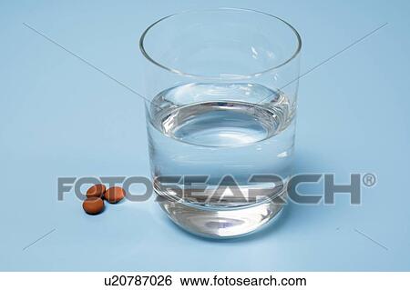 Medication and glass of water on a blue background. View Large Photo Image Stock Photograph - Medication and glass of water on a blue background.. Fotosearch