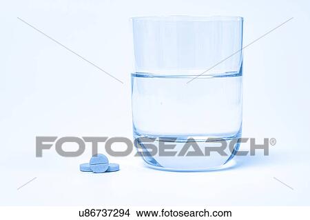 Picture - Medication and glass of water on a white background.. Fotosearch