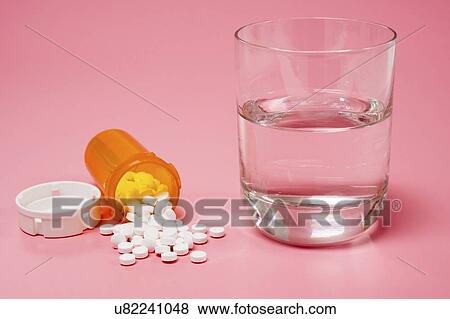 Medication and glass of water on a red background. View Large Photo Image Stock Photo - Medication and glass of water on a red background.. Fotosearch