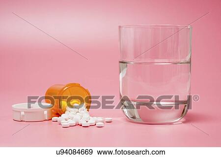 Medication and glass of water on a red background. View Large Photo Image Stock Photo - Medication and glass of water on a red background.. Fotosearch