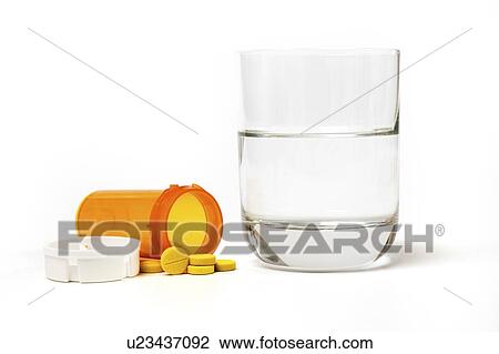 Stock Image - Medication and glass of water on a white background.. Fotosearch