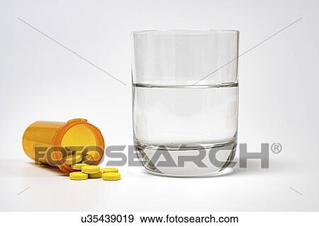 Stock Photo - Medication and glass of water on a white background.. Fotosearch