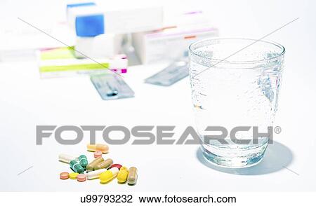 Stock Image - Medicines and glass of water.. Fotosearch