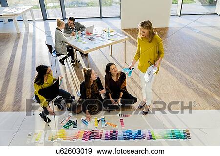 Stock Photo - Mentor and colleagues working with colour swatches. Fotosearch