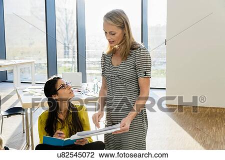 Stock Image - Mentor working with colleague. Fotosearch