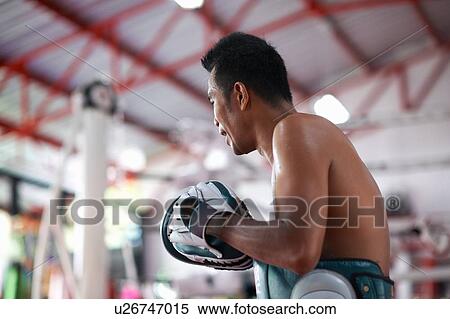 Stock Photography - Mid adult male boxer training in gym. Fotosearch