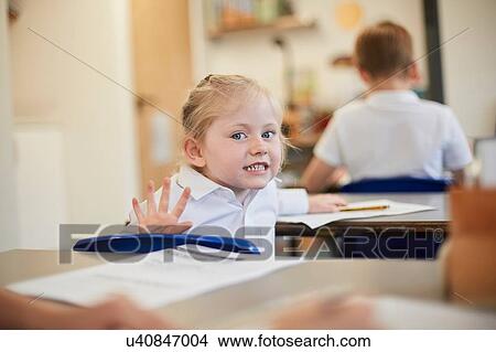Mischievous schoolgirl in classroom lesson at primary school View Large Photo Image Picture - Mischievous schoolgirl in classroom lesson at primary school. Fotosearch