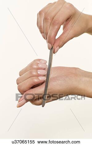 MODEL RELEASED. Young woman filing fingernails with emery board. View Large Photo Image Stock Photography - MODEL RELEASED. Young woman filing fingernails with emery board.. Fotosearch