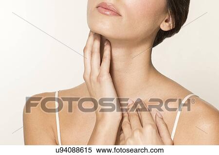 Stock Photography - MODEL RELEASED. Young woman rubbing neck, cropped portrait.. Fotosearch
