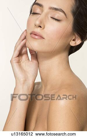 MODEL RELEASED. Young woman touching face with eyes closed, portrait. View Large Photo Image Stock Image - MODEL RELEASED. Young woman touching face with eyes closed, portrait.. Fotosearch