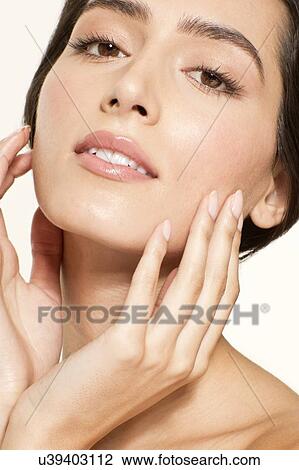 MODEL RELEASED. Young woman touching face, portrait. View Large Photo Image Stock Image - MODEL RELEASED. Young woman touching face, portrait.. Fotosearch